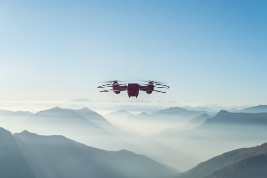 Drone in sky above mountains sunny day