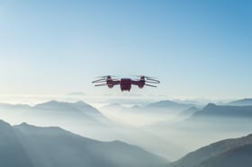 Drone in sky above mountains sunny day