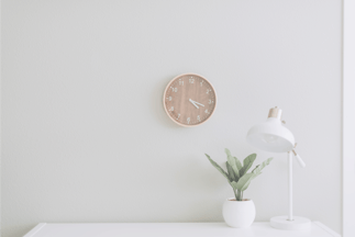 office white wall with clock, lamp and pot plant