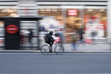 Man on pedal bike outside bus stop in London